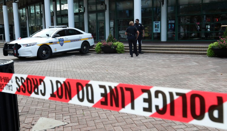 Jacksonville police officers guard an area Monday, Aug. 27, 2018, near the scene of a fatal shooting at The Jacksonville Landing on Sunday in Jacksonville, Fla.