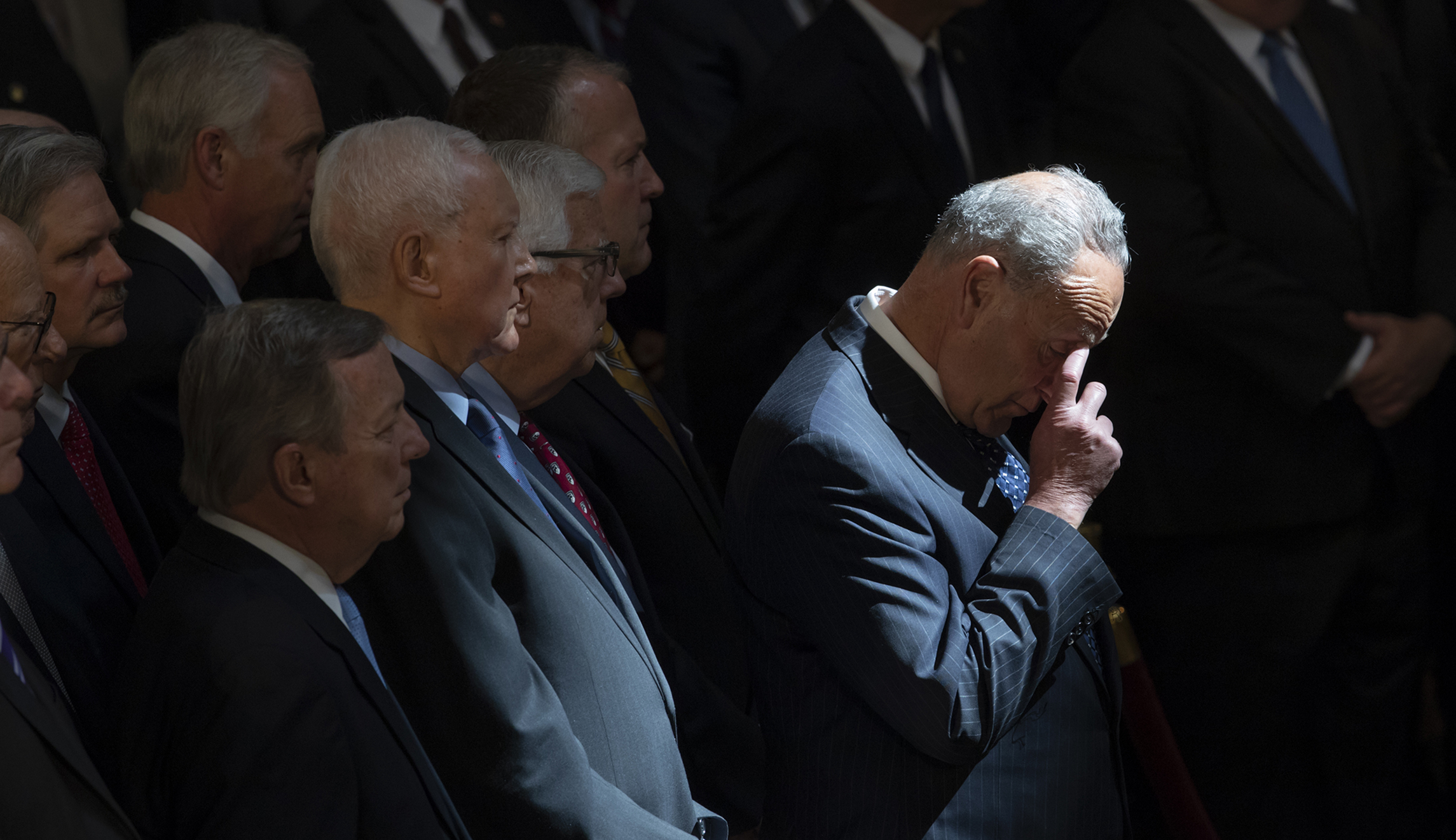 Senate Minority Leader Chuck Schumer, D-N.Y., center, and other members of the Senate, stand as the flag-draped casket bearing the remains of Sen. John McCain of Arizona, lies in state in the U.S. Capitol rotunda for a farewell ceremony and public visitation, Friday, Aug. 31, 2018, in Washington.  