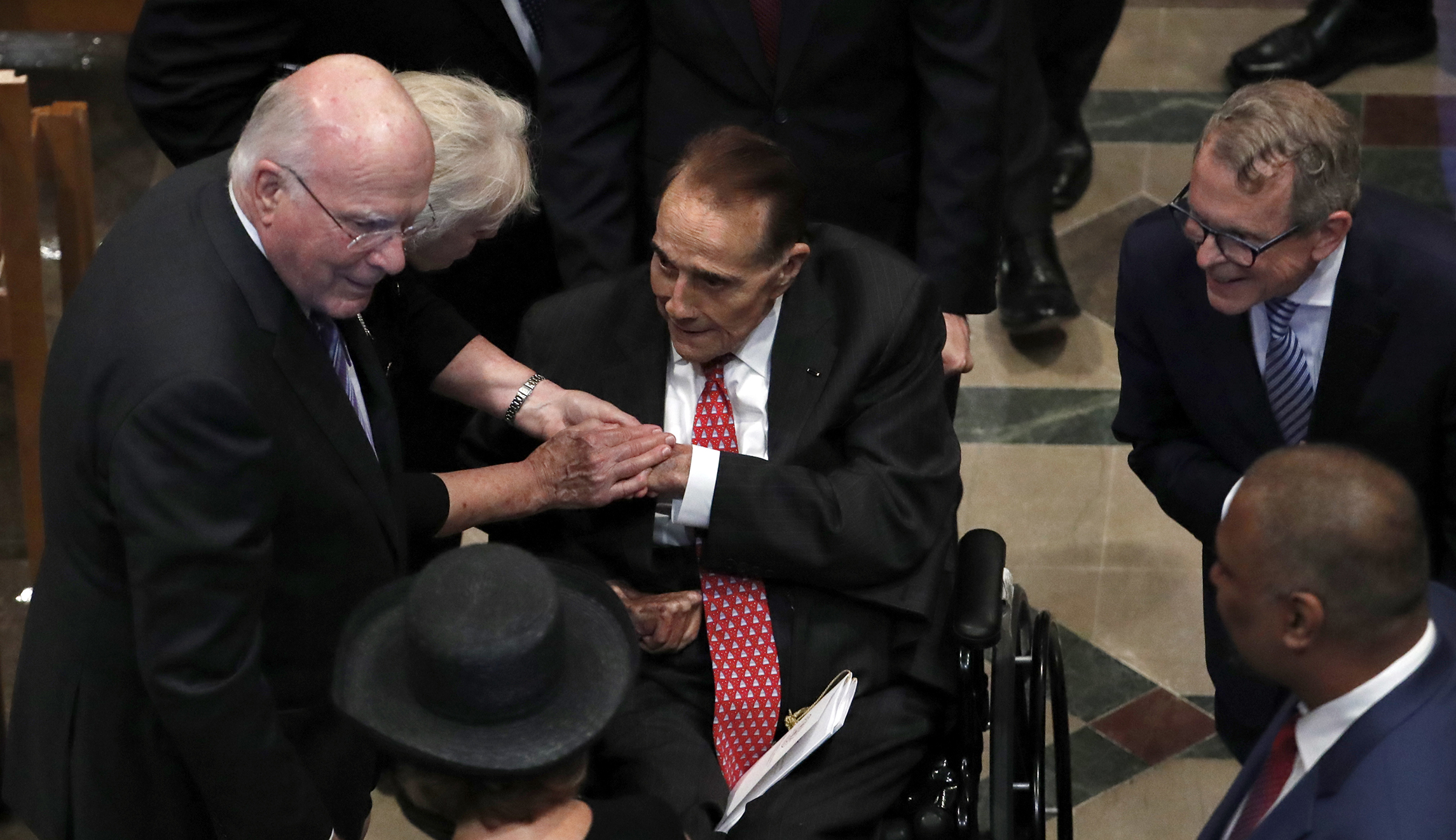 Sen. Patrick Leahy, D-Vt., and his wife Marcelle, greet former Sen. Bob Dole, center, as they arrive for a memorial service for Sen. John McCain, R-Ariz., at Washington National Cathedral in Washington on Saturday.