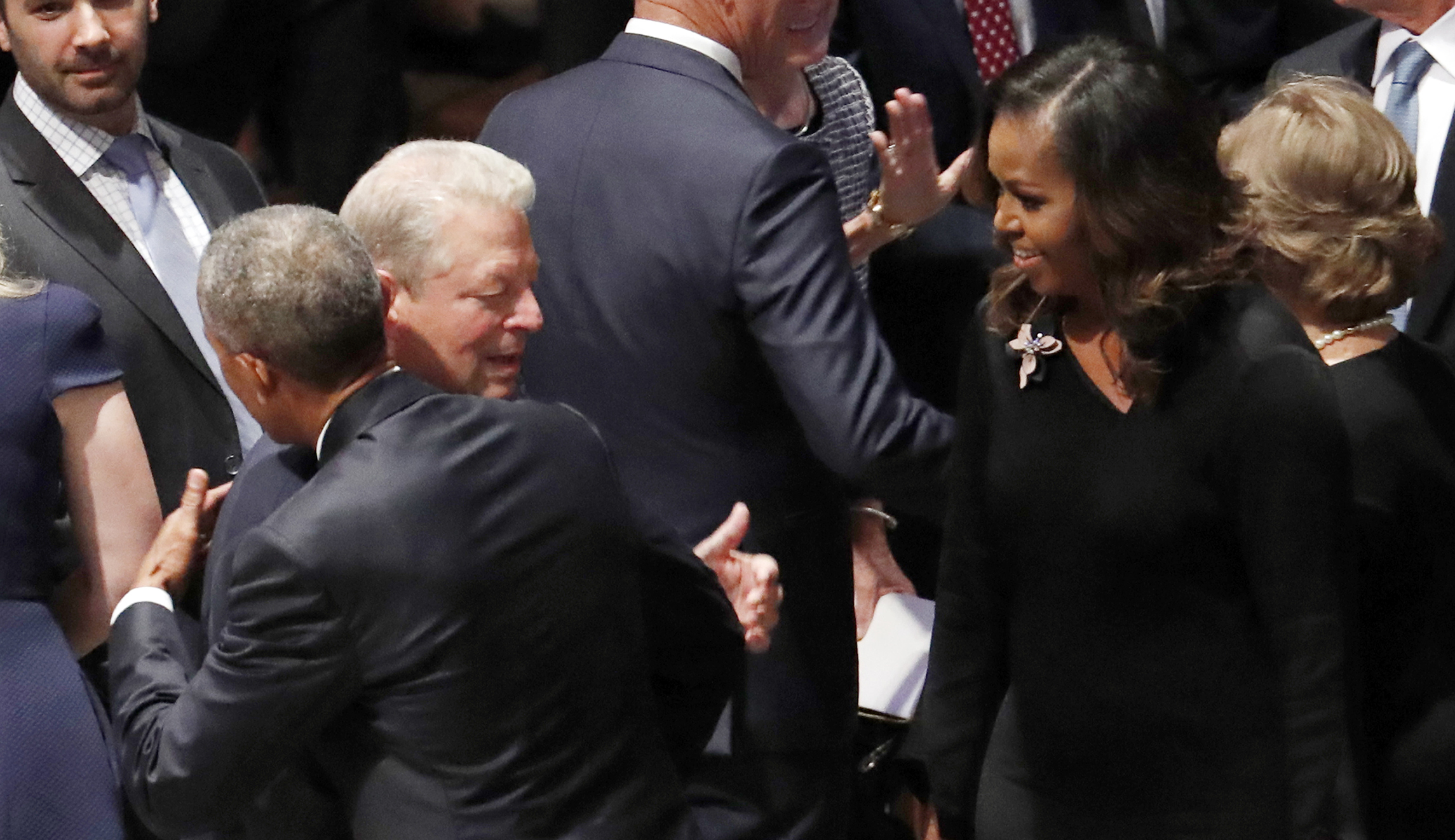 Former President Barack Obama hugs former Vice President Al Gore as former first lady Michelle Obama watches before the memorial service for Sen. John McCain, R-Ariz., at Washington National Cathedral on Saturday.