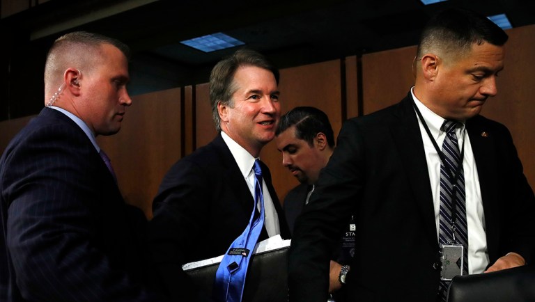 President Trump's Supreme Court nominee, Brett Kavanaugh, center, leaves the hearing room in the evening.
