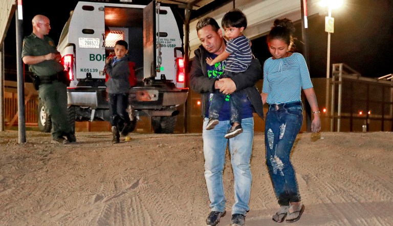 FILE - In this July 18, 2018 file photo, a Honduran man carries his 3-year-old son as his daughter and other son follow to a transport vehicle after being detained by U.S. Customs and Border Patrol agents in San Luis, Ariz. Border arrests figures for August 2018, are the latest reminder of how crossings have shifted over the last decade from predominantly Mexican men to Central American families and children. The number of family arrivals reached 15,955, a sharp increase from July that Customs and Border Protection Commissioner Kevin McAleenan said was one of the highest on record.