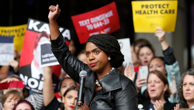 Ayanna Pressley holds up her fist after speaking at a rally.