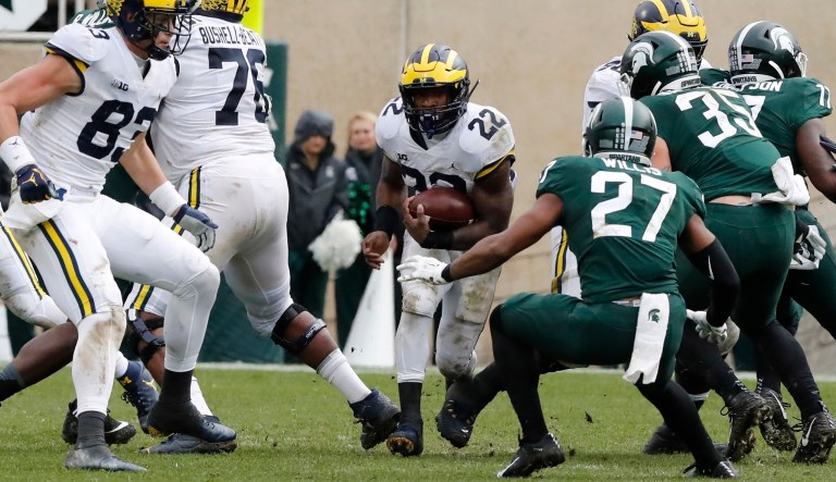 Michigan running back Karan Higdon (22) breaks through the Michigan State line during the second half of an NCAA college football game, Saturday, Oct. 20, 2018, in East Lansing, Mich.