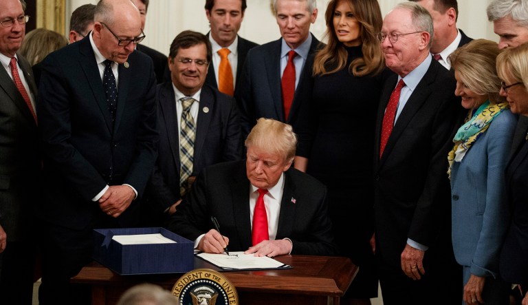 President Donald Trump signs legislation combating the opioid epidemic, in the East Room of the White House, Wednesday, Oct. 24, 2018, in Washington.