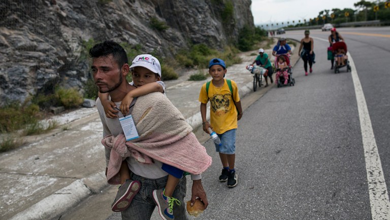 Honduran migrant Jose Macy carries his four-year-old nephew Yair Perez as the thousands-strong caravan of Central Americans migrants hoping to reach the U.S. border moves onward from Juchitan, Oaxaca state, Mexico.