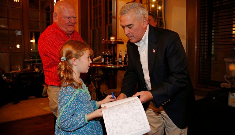 Rep. Brad Wenstrup, R-Ohio, right, signs a book for Sydney Smith, 8, during an election night watch party Tuesday, Nov. 6, 2018, in Cincinnati, Ohio.