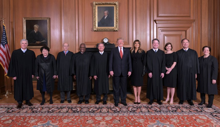 In this image provided by the Supreme Court, President Donald Trump poses for a photo with Associate Justice Brett Kavanaugh in the Justices' Conference Room before a investiture ceremony Thursday, Nov. 8, 2018, at the Supreme Court in Washington. From left are, Associate Justices Neil Gorsuch, Sonia Sotomayor, Stephen Breyer, Clarence Thomas, Chief Justice John Roberts, Jr., President Donald Trump, first lady Melania Trump, Associate Justice Brett Kavanaugh, Ashley Kavanaugh, and Associate Justices Samuel Alito, Jr. and Elena Kagan.