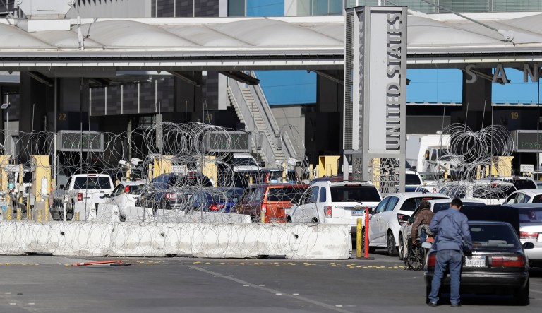 Barricades with concertina wire block three lanes at the San Ysidro port of entry Wednesday, Nov. 14, 2018, as seen from Tijuana, Mexico. Migrants in a caravan of Central Americans scrambled to reach the U.S. border, catching rides on buses and trucks for hundreds of miles in the last leg of their journey Wednesday as the first sizable groups began arriving in the border city of Tijuana.