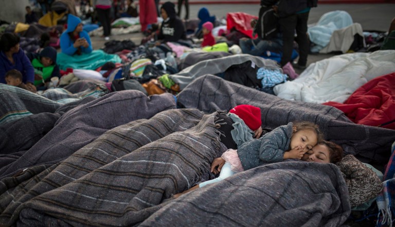 Julia Romero, 4, snuggles with her mother Lurvin Sarmiento, from Honduras, as they wake from their sleep, at the Chaparral border crossing in Tijuana, Mexico, Friday, Nov. 23, 2018. The mayor of Tijuana has declared a humanitarian crisis in his border city and says that he has asked the United Nations for aid to deal with the approximately 5,000 Central American migrants who have arrived in the city.