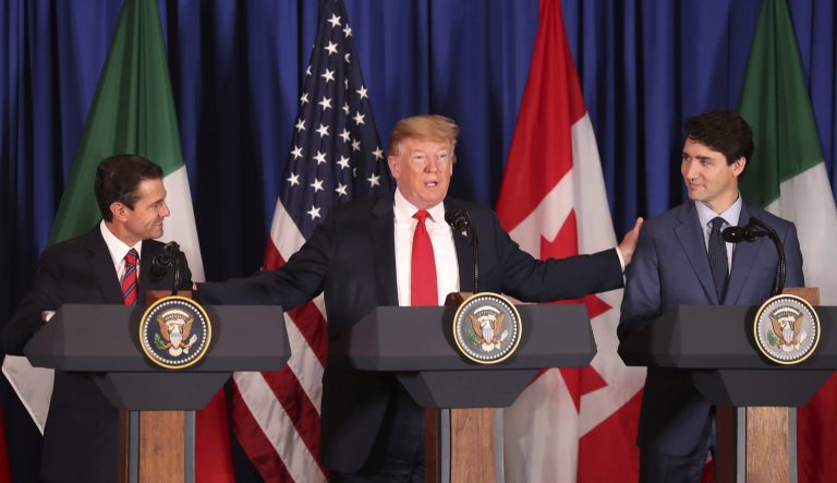 President Donald Trump, center, reaches out to Mexico's President Enrique Pena Nieto, left, and Canada's Prime Minister Justin Trudeau as they prepare to sign a new United States-Mexico-Canada Agreement replacing the NAFTA trade deal, during a ceremony before the start of the G20 summit in Buenos Aires, Argentina, Friday, Nov. 30, 2018. 