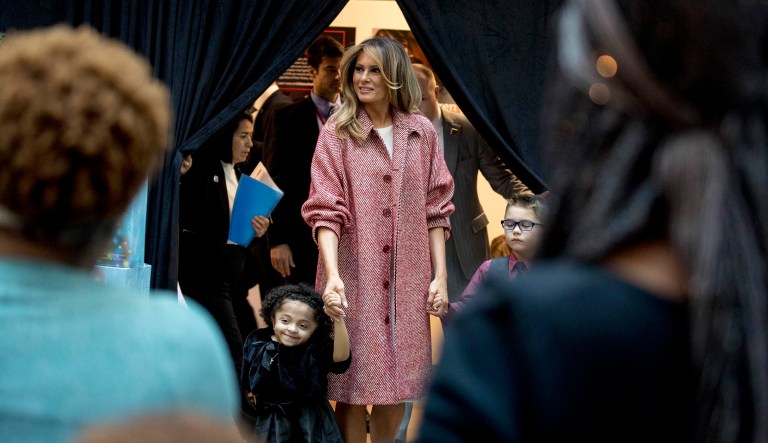 First lady Melania Trump, arrives with Tearrianna Cooke-Starkey, left, and Nathan Simm, right, to read "Oliver the Ornament" to children at Children's National Health System on Thursday in D.C.
