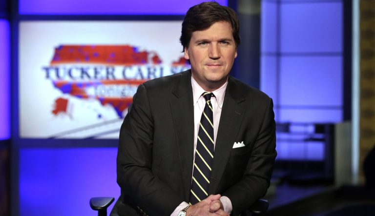 In this March 2, 2017 photo, Tucker Carlson, host of "Tucker Carlson Tonight," poses for photos in a Fox News Channel studio in New York. 
