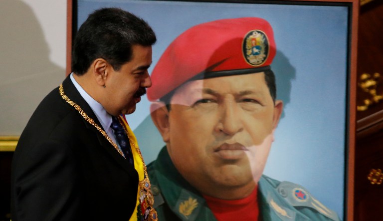 Venezuela's President Nicolas Maduro walks past a painting of his predecessor, late President Hugo Chavez, inside the chambers of the Constitutional Assembly where he will give his annual address to the nation in Caracas, Venezuela, Monday, Jan. 14, 2019.