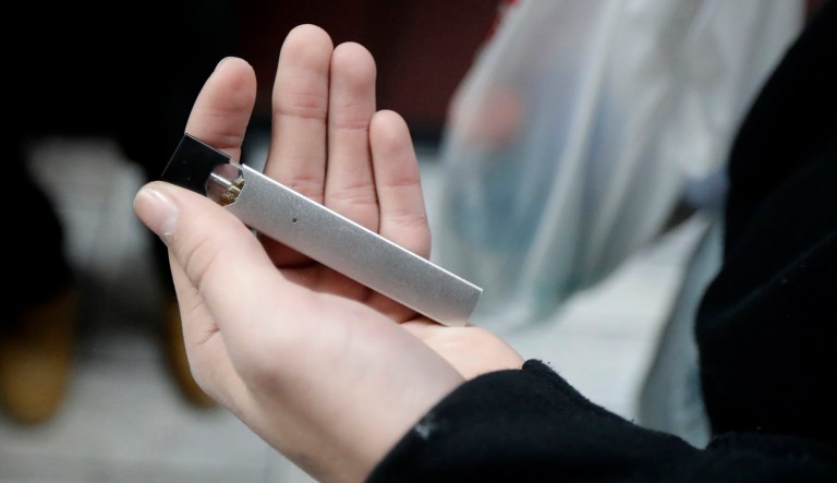 A man displays his Juul electronic cigarette while shopping at a convenience store in Hoboken, New Jersey.