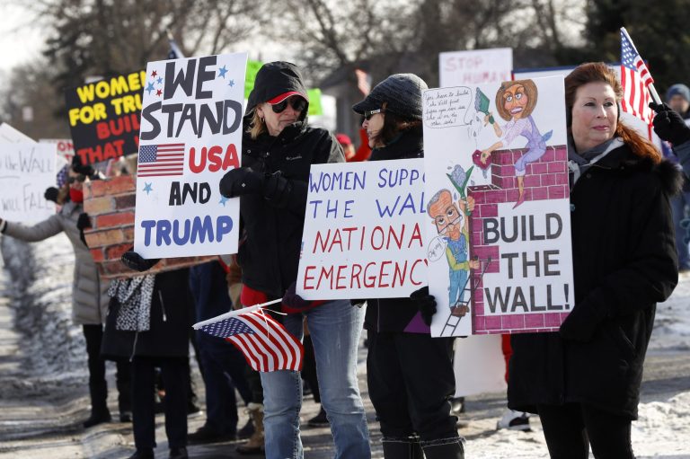 Supporters hold signs at a women for Trump "Build the Wall" rally in Bloomfield Hills, Mich., Saturday, Jan. 26, 2019.