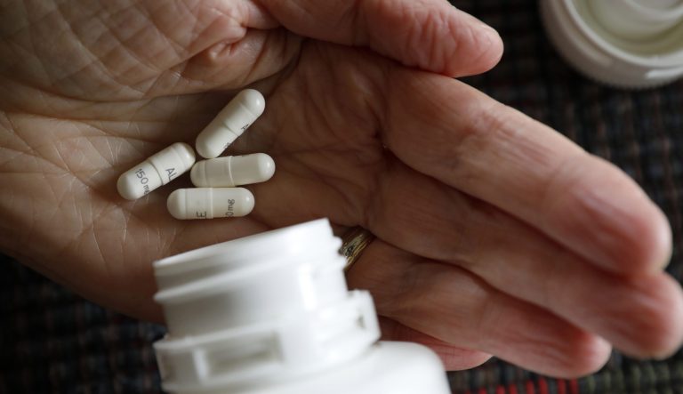 Retired public school teacher Gail Orcutt, of Altoona, Iowa, holds some of the prescription drugs she takes, Friday, Feb. 15, 2019, in Altoona, Iowa.