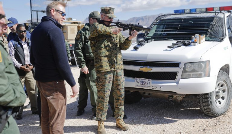 Acting Secretary of Defense Patrick Shanahan, left, watches as Joint Chiefs Chairman Gen. Joseph Dunford, center, fire a Border Patrol weapon during a tour of the US-Mexico border at Santa Teresa Station in Sunland Park, N.M., Saturday, Feb. 23, 2019. 