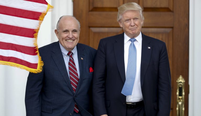 In this Nov. 20, 2016 photo, then-President-elect Donald Trump, right, and former New York Mayor Rudy Giuliani pose for photographs as Giuliani arrives at the Trump National Golf Club Bedminster clubhouse in Bedminster, N.J.