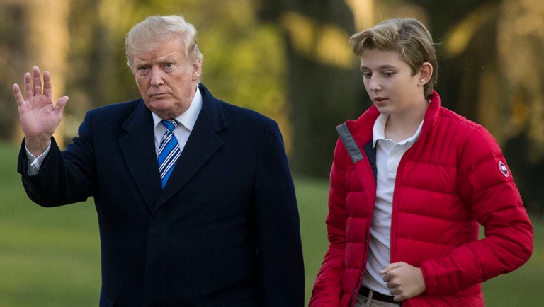 President Donald Trump, accompanied by his son Barron Trump, 12, walks on the South Lawn after stepping off Marine One.