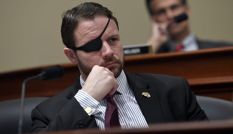Rep. Dan Crenshaw, R-Texas, left, listens as Office of Management and Budget Acting Director Russell Vought testifies before the House Budget Committee on Capitol Hill in Washington, Tuesday, March 12, 2019, during a hearing on the fiscal year 2020 budget. 
