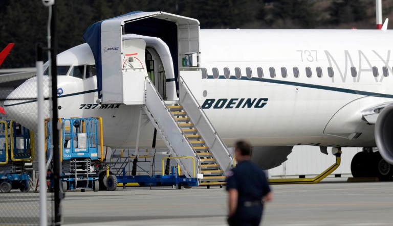 A worker walks next to a Boeing 737 MAX 8 airplane parked at Boeing Field, Thursday, March 14, 2019, in Seattle.