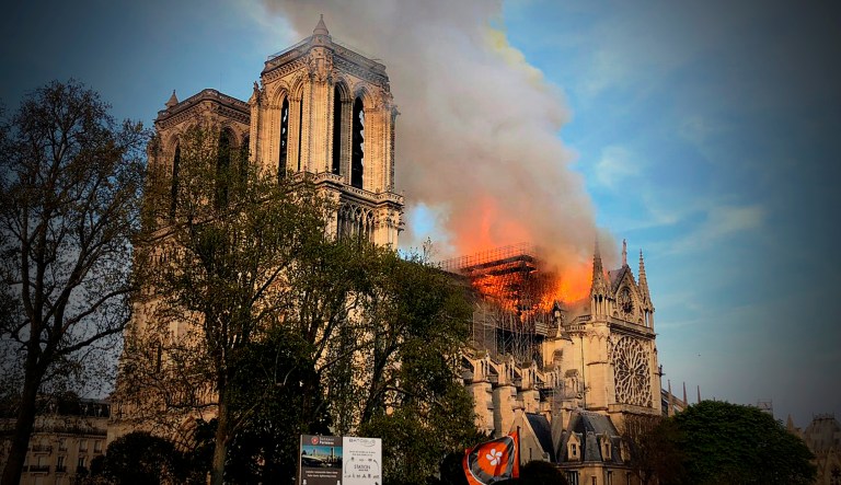 Notre Dame cathedral is burning in Paris, Monday, April 15, 2019. Massive plumes of yellow brown smoke is filling the air above Notre Dame Cathedral and ash is falling on tourists and others around the island that marks the center of Paris. 