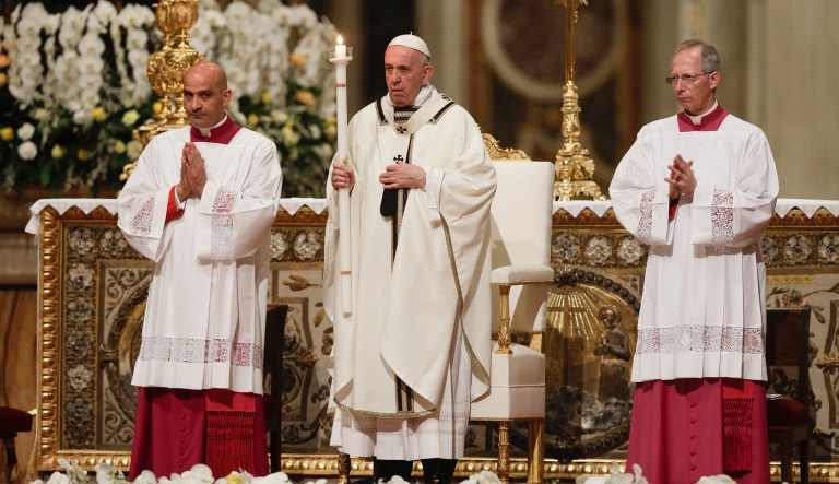 Pope Francis holds a candle as he presides over a solemn Easter vigil ceremony in St. Peter's Basilica at the Vatican, Saturday, April 21, 2019.