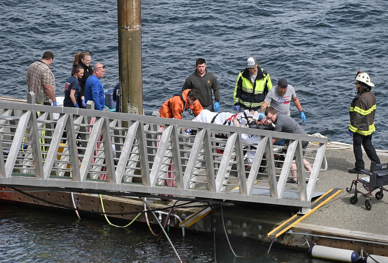 Emergency response crews transport an injured passenger to an ambulance at the George Inlet Lodge docks, Monday, May 13, 2019, in Ketchikan, Alaska.