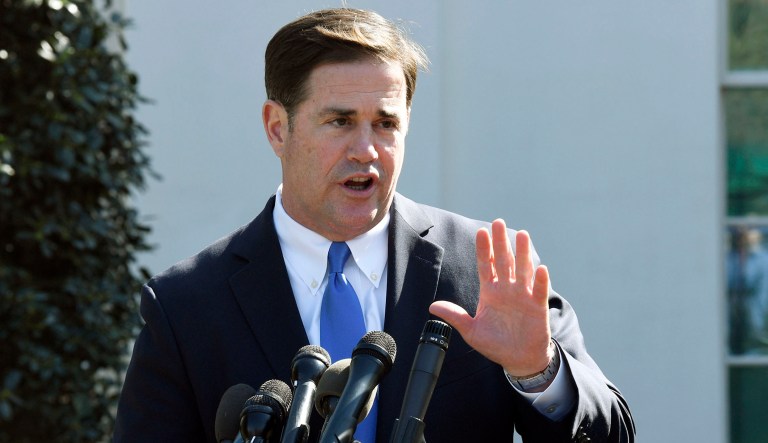 Arizona Gov. Doug Ducey talks to reporters outside the West Wing of the White House in Washington.