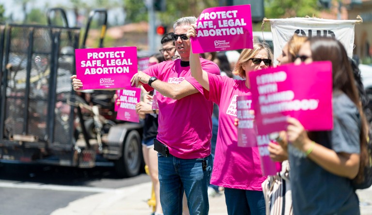 Protestors hold signs during Stop the Bans Speak Out Tour at the corner of Culver Drive and Alton Parkway in Irvine, Calif., on Wednesday, June 19, 2019. The pro-choice rally was part of a week of protests in San Bernardino and Orange counties against recent abortion bans and stricter laws nationwide. Similar lunchtime rallies will be held Thursday in Brea and Friday in Huntington Beach.