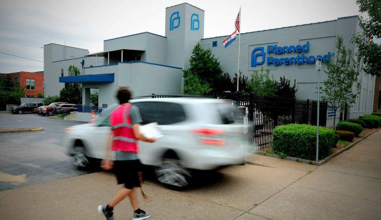 An anti-abortion advocate attempts to solicit a motorist entering the parking lot of the Planned Parenthood of the St. Louis Region and Southwest Missouri, the state's last operating abortion clinic in St. Louis.