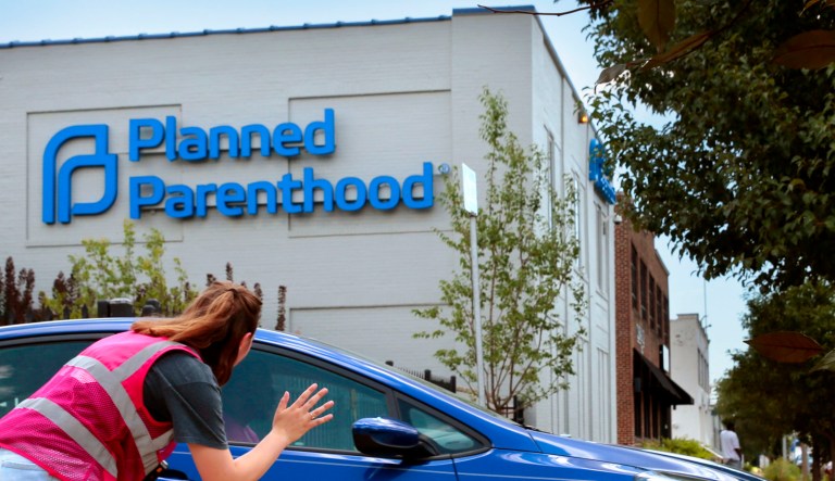 Ashlyn Myers of the Coalition for Life St. Louis waves to a Planned Parenthood staff member.