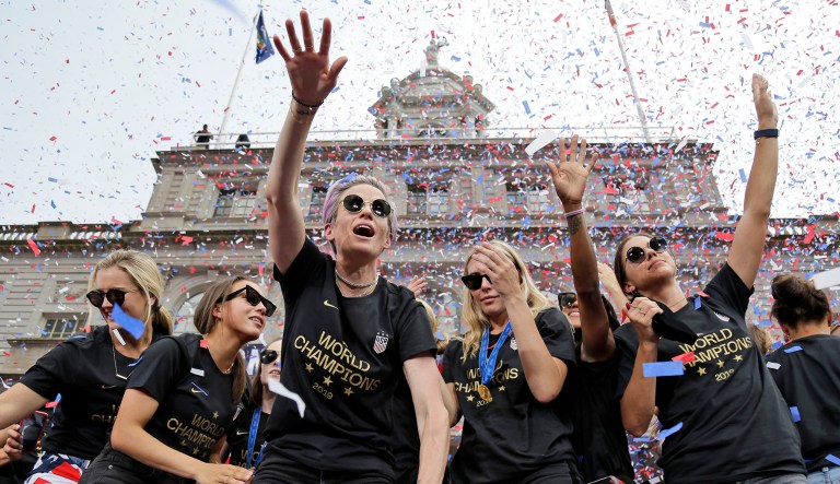 Megan Rapinoe, center, and Alex Morgan, right, celebrates with U.S. women's soccer teammates at City Hall after a ticker tape parade in New York.