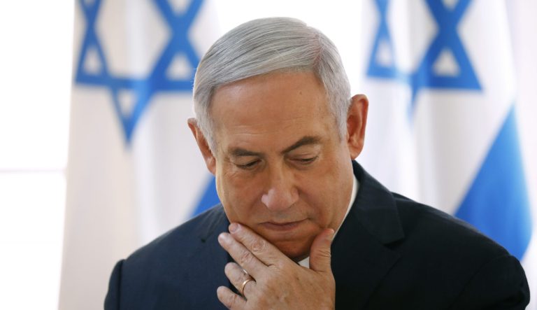 Israeli Prime Minister Benjamin Netanyahu holds up a placard given to him as a gift from Israeli residents of the area, at the start of a weekly cabinet meeting being held in a makeshift tent in the Jordan Valley, in the Israeli-occupied West Bank, Sunday, Sept. 15, 2019. 