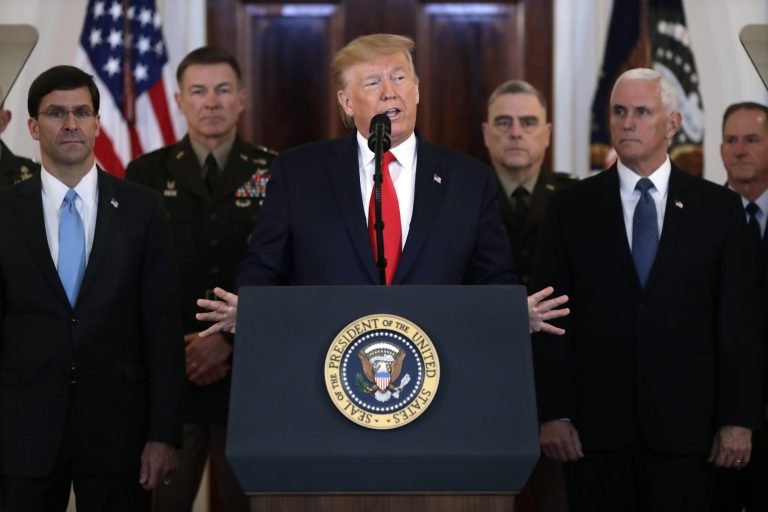 President Donald Trump addresses the nation from the White House on the ballistic missile strike that Iran launched against Iraqi air bases housing U.S. troops, Wednesday, Jan. 8, 2020, in Washington, as Vice President Mike Pence and others looks on.