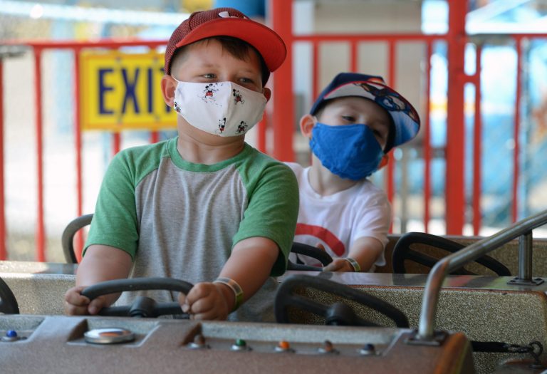 Xavier Szlabonyi, 5, left, and Jack Hubacher, 4, both of Buffalo, N.Y., ride the Umbrella Ride, on July 3 at Waldameer Park & Water World in Millcreek Township, Pa. New rules exist at the park this year due to the COVID-19 pandemic. (Jack Hanrahan/Erie Times-News via AP)