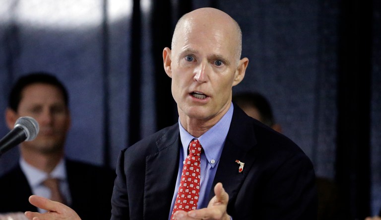 Florida Gov. Rick Scott gestures during a meeting.