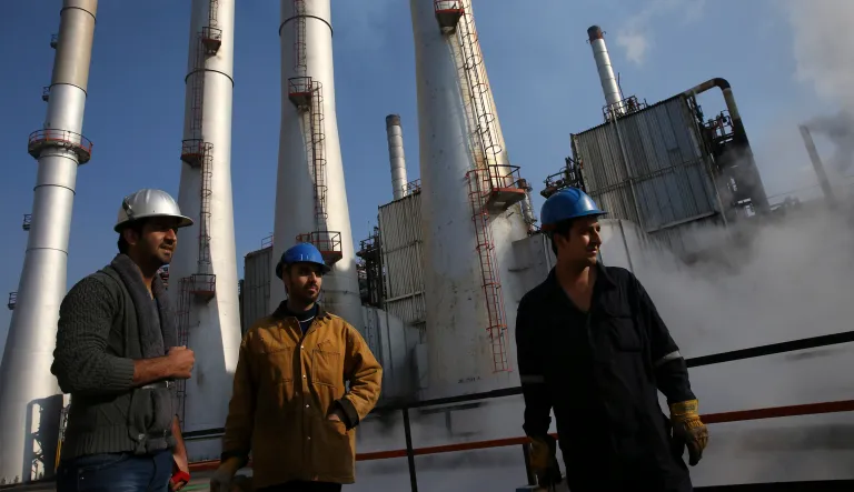 In this Dec. 22, 2014 file photo, Iranian oil workers gather at the Tehran's oil refinery south of the capital Tehran, Iran. Across a Mideast fueled by oil production, low global prices have some countries running on empty and scrambling to cover shortfalls, even as more regional crude is on tap to enter the market.