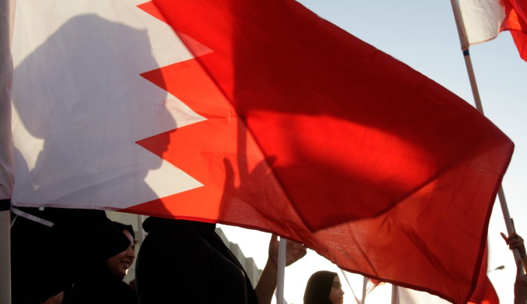 In this photo, people wave national flags in Bahrain.