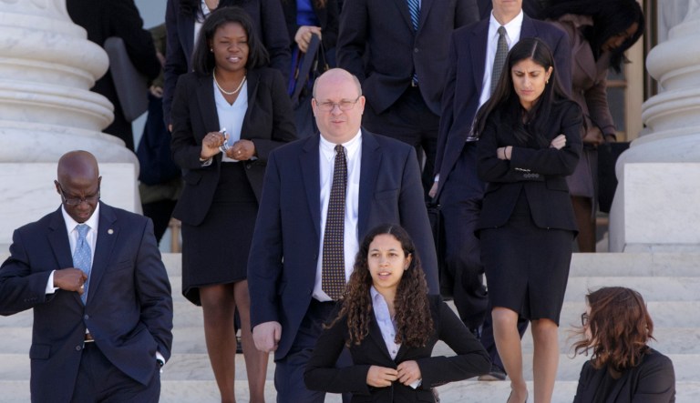 Attorney Marc Elias, center, leaves the Supreme Court in Washington, Monday, March 21, 2016.