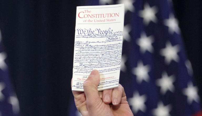 House Speaker Paul Ryan of Wis. holds a copy of the Constitution as he decries ugliness and divisiveness in American politics, delivering a veiled but passionate rebuke to GOP presidential front-runner Donald Trump and the nasty tone of the presidential campaign as he addressed congressional interns, Wednesday, March 23, 2016, on Capitol Hill in Washington.