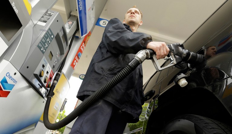 A man pumps gas at a station in Portland, Ore.