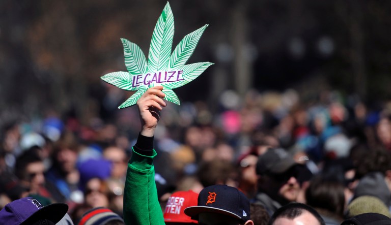 A man holds up a sign advocating the legalization of marijuana. Michigan voters will decide whether to legalize the recreational use of marijuana in a public vote in November.
