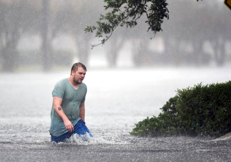 Jake Head walks through heavy rain from tropical storm Florence in Wilmington, N.C., Saturday, Sept. 15, 2018. (Matt Born/The Star-News via AP)