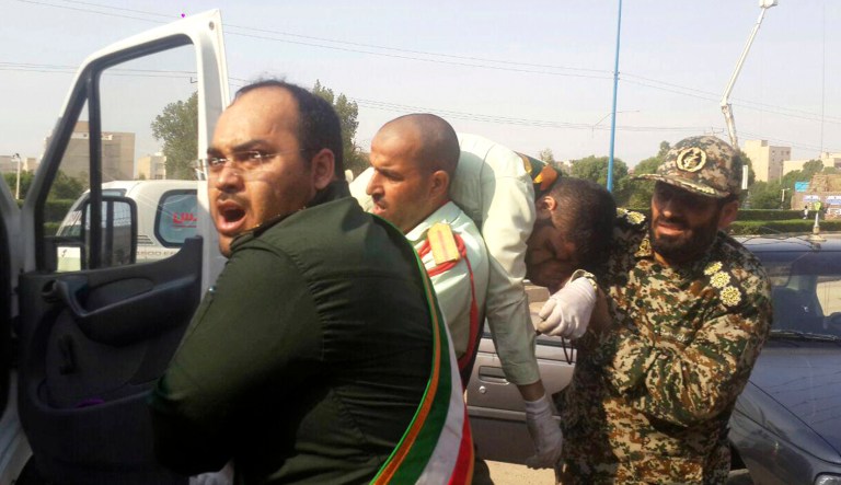 Members of Iran's Revolutionary Guard carry a wounded person after a shooting during their parade marking the 38th anniversary of Iraq's 1980 invasion of Iran, in the southwestern city of Ahvaz, Iran, on Saturday.