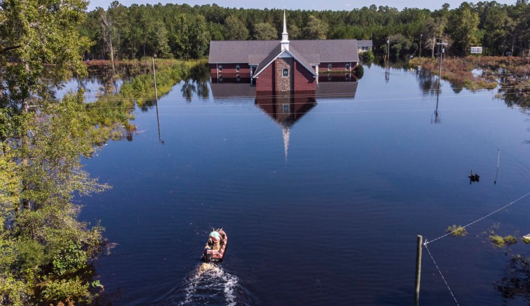 Avery Singleton takes a boat to Pine Grove Baptist Church, Saturday, Sept. 22, 2018, in Brittons Neck, S.C.