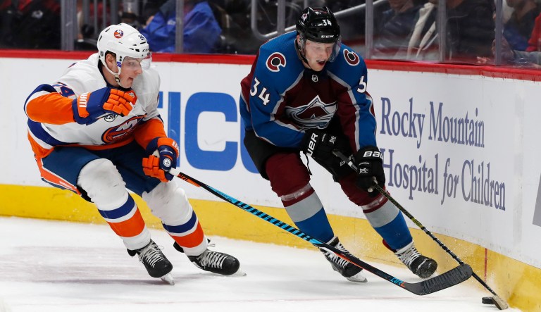 New York Islanders defenseman Scott Mayfield, left, pursues the puck with Colorado Avalanche center Carl Soderberg in the third period of an NHL hockey game Monday, Dec. 17, 2018, in Denver.