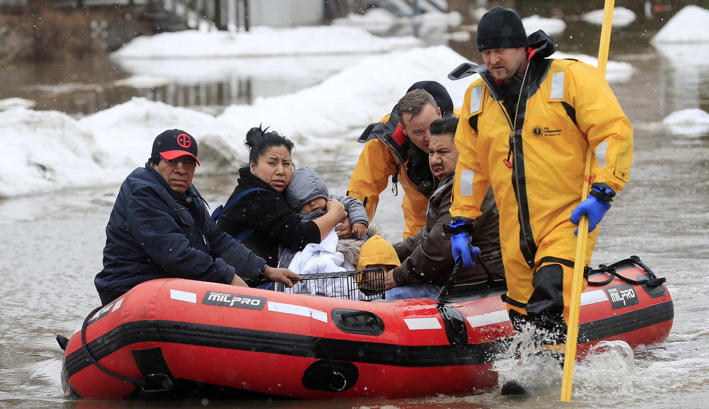 Green Bay firefighters assist residents in evacuating their homes due to the East river flooding on Friday in Green Bay, Wis. Heavy rain falling atop deeply frozen ground has prompted evacuations along swollen rivers in Wisconsin, Nebraska and other Midwestern states, while powerful wind and snow has impacted hundreds of miles of interstates in North Dakota.