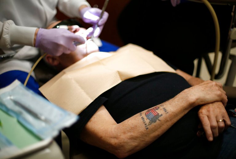 Vietnam Veteran Terry White, of Whitinsville, Mass., crosses his arms as he undergoes a dental procedure at the Aspen Dental Day of Service event on Saturday June 8, 2019 in Auburn, Mass.